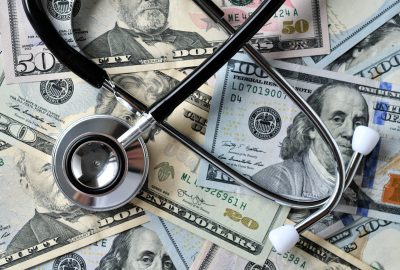 Stethoscope laying on money - Medical costs, doctor's bills, cost of insurance HSA FSA medical